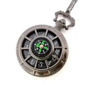 Detailed close-up of the vintage metal pocket watch featuring an integrated compass dial.