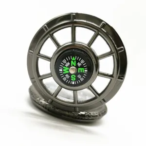 Detailed view of a metal pocket watch with a unique ship wheel design and compass face.