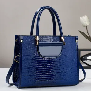 Close-up van de glanzende blauwe krokodillenpatroon handtas met fijne textuur en metalen hardware.