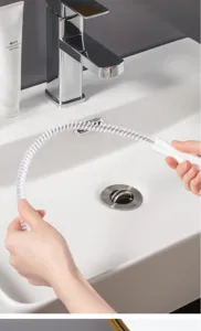 Dettaglio della spazzola per scarico con setole bianche flessibili per pulizia lavandino bagno.