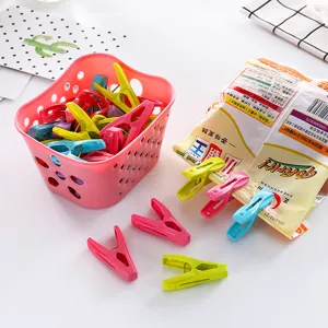 Colorful plastic clothes pegs with storage basket for daily laundry drying tasks.