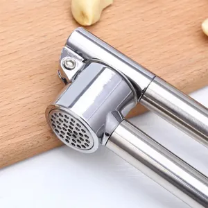 Stainless steel garlic press manual kitchen tool for crushing garlic cloves efficiently and easily.