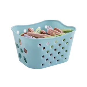 Plastic storage basket with colorful clothespins set for home laundry drying organization.