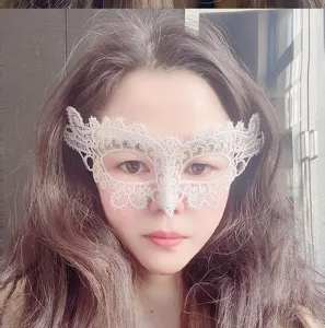 Detailansicht einer weißen Spitzenmaske für Maskerade im Gesicht, ideal für Partykostüme.