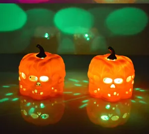 Detail view of glowing Halloween LED pumpkin lights with skull design and colorful projection.