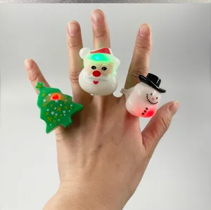 Close-up of Christmas LED flashing rings, featuring cute Santa, snowman and tree cartoon designs.
