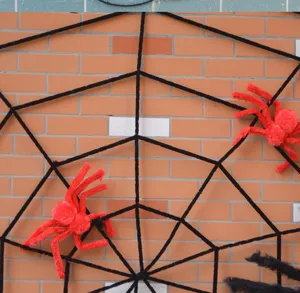 Halloween Spinnennetz Dekoration mit roten Plueschspinnen fuer gruselige Party und Bar.