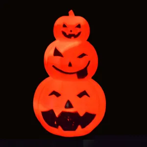 Detailed close-up of glowing stacked Halloween pumpkin light featuring spooky jack-o-lantern faces.