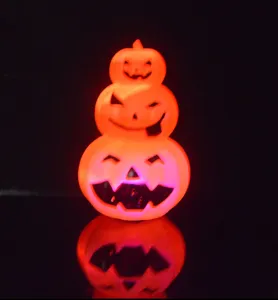 Detailed view of a glowing 3-tiered Halloween pumpkin light featuring carved jack-o'-lantern faces.
