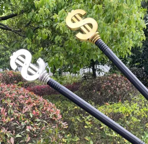 Close-up detail of the golden and silver dollar sign scepter props for party decoration.