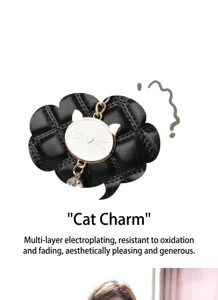 Detailaufnahme einer schwarzen Stepptasche mit einem charmanten goldenen Katzenanhänger