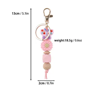 Detailed view of pink silicone bead keychain featuring butterfly and daisy flower pendants
