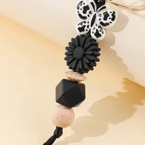 Macro detail of the leopard print butterfly and black daisy beads on a stylish keychain
