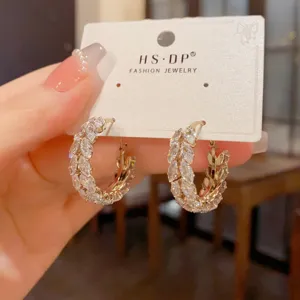 Close-up of elegant gold hoop earrings featuring marquise zircon wheat ear design