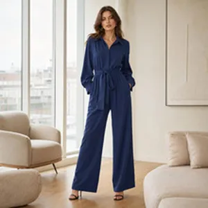 Elegant navy blue long sleeve jumpsuit with waist belt and wide legs in a home setting