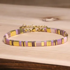 Vue détaillée d'un bracelet en perles Tila avec carrés violets et dorés