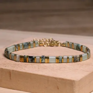 Gros plan d'un bracelet en perles Tila de style ethnique aux motifs de marbre vert et doré