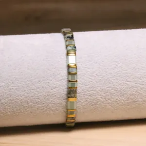 Gros plan détaillé d'un bracelet en perles Tila bohème avec pierres naturelles et dorées