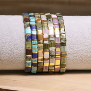Gros plan de bracelets en perles Tila colorées avec motifs bohèmes et accents dorés.