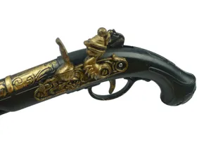 Close-up detail of vintage pirate flintlock gun prop, black and gold cosplay accessory.