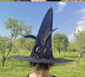 Dettaglio del cappello da strega nero con rose, piume e catena per festa di Halloween.
