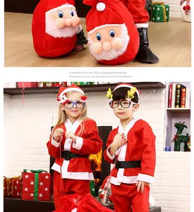 Vue rapprochée d'enfants portant un ensemble de costume de noël rouge festif avec sac dans la scène.
