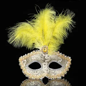 Detailansicht der venezianischen Maske mit gelben Federn, Goldspitze und glänzenden Strasssteinen.
