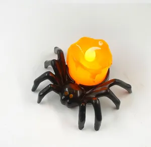 Close up view of the black spider LED electronic candle light with orange melted wax design.