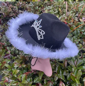 Black western cowboy hat with white fluffy feathers and rhinestone crown decoration for party.
