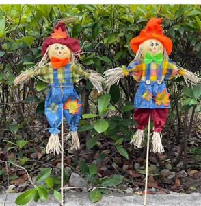 Detail view of handmade scarecrow garden ornaments with colorful autumn hats and plaid outfits.