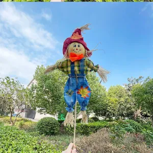 Handmade straw scarecrow doll detail showing colorful plaid shirt and denim overalls design.