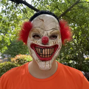 Scary Halloween clown mask with red hair and creepy grin design for party cosplay events.