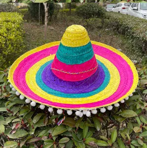 Colorful Mexican straw sombrero hat with vibrant rings and pom poms for festive party decoration.