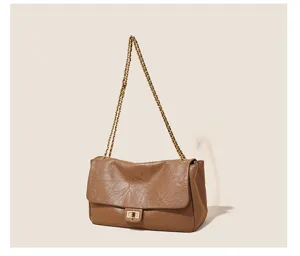 Detailed view of the vintage brown leather shoulder bag featuring a metallic chain strap.