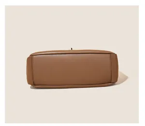 Close-up detail of the bottom structure of a brown leather shoulder bag, neat stitching.