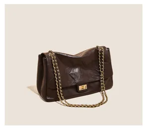 Dark brown leather shoulder bag with gold chain strap, vintage quilted design detail.