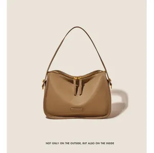 Close-up detail of the stylish soft leather shoulder handbag, elegant brown tone and metal hardware.