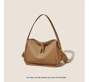 Detail view of the soft leather shoulder bag with smooth zipper and golden hardware accents.