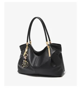 Classic black leather shoulder bag with chic gold hardware and a cute fox charm detail.