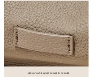 Detailed view of genuine leather handbag texture, premium grain surface and fine stitching.