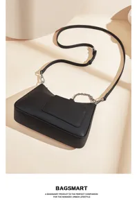 Black leather shoulder bag detail, stylish crescent axilla bag with metal chain accent.
