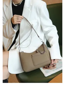 Genuine leather crescent shoulder bag for women, stylish underarm hobo bag with chain detail.