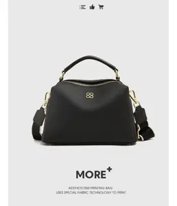 Detail view of black genuine leather pillow bag with top handle and shoulder strap fashion.