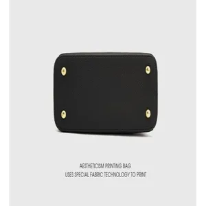 Detailed bottom view of genuine leather handbag with metal feet and special fabric texture.