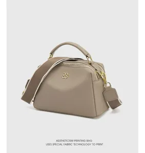 Detailed view of the gray leather handbag featuring metal hardware and textured cowhide.