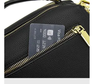 Black leather handbag zipper detail close-up showing premium texture and gold hardware.