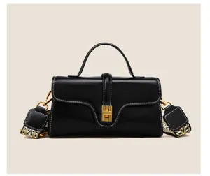 Black genuine leather top handle shoulder bag with wide strap and metallic clasp detail.