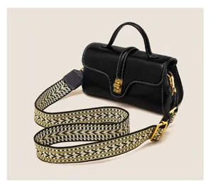 Black leather top handle bag with wide patterned strap, elegant design for women daily use.