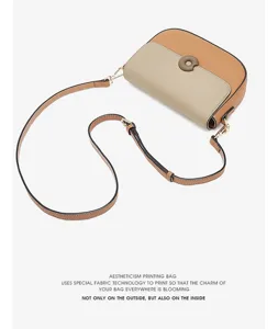 Stylish women's contrast color leather crossbody saddle bag with chic round buckle detail.
