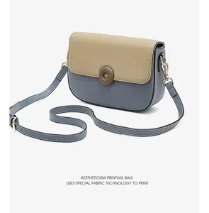 Top layer cowhide contrast color women crossbody saddle bag with special fabric round button.